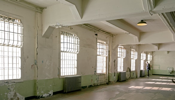 Alcatraz mess hall interior with barred windows and peeling paint.