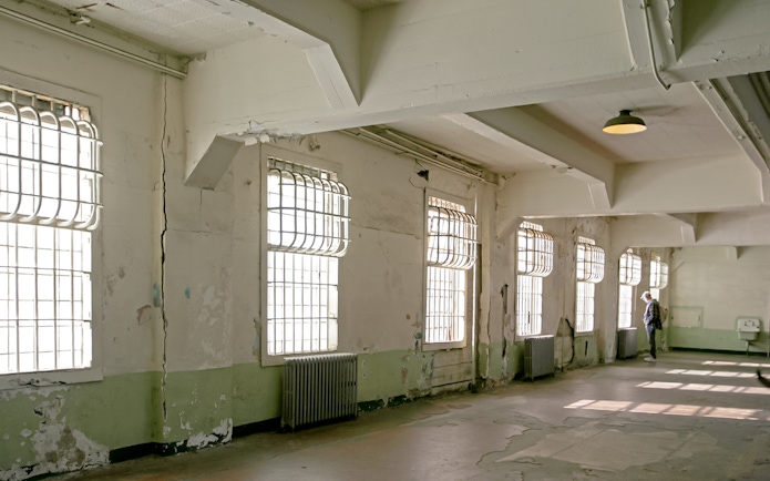 Alcatraz mess hall interior with barred windows and peeling paint.