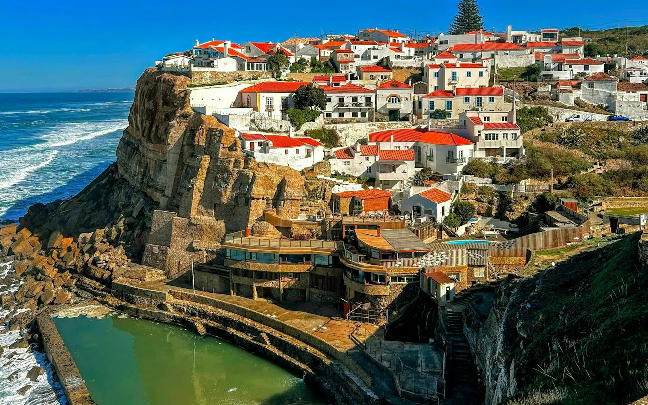 Cliffside village with red-roofed houses in Azenhas do Mar, a stop on the Lisbon to Porto transfer.