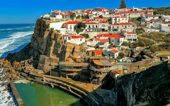 Cliffside village with red-roofed houses in Azenhas do Mar, a stop on the Lisbon to Porto transfer.