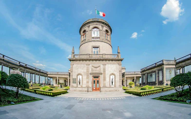 Chapultepec Castle exterior with central tower and Mexican flag in Mexico City.