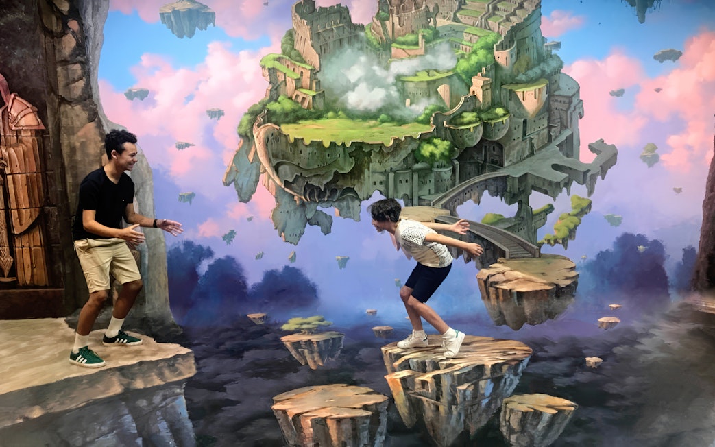 Visitors interacting with floating island illusion at ArtVo Melbourne Trick-Art Gallery.