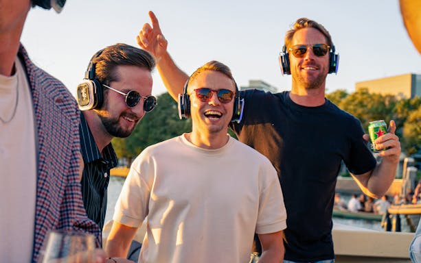 People enjoying a silent disco on an Amsterdam party cruise.