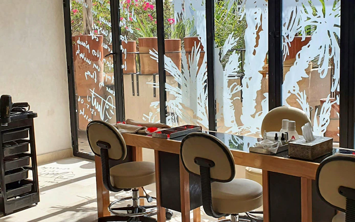 Nail salon area at Le Bain Bleu Hammam & Spa, Marrakesh with chairs and manicure tools.