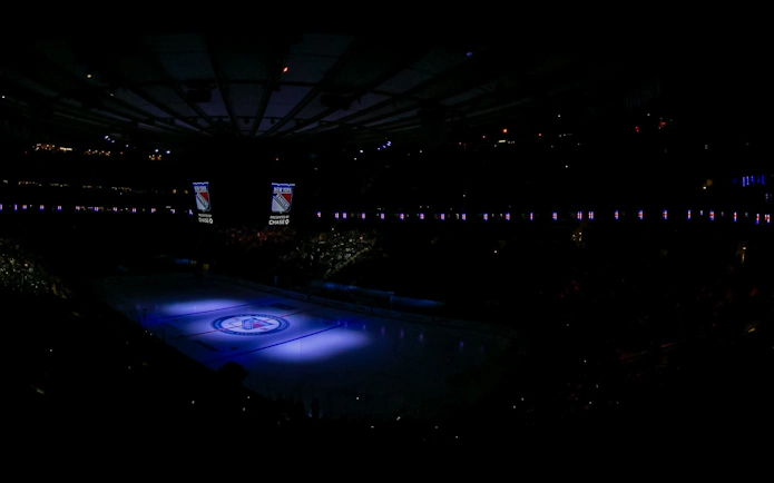 New York Rangers logo projected on ice at Madison Square Garden.