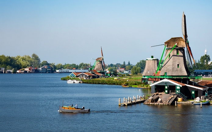 Zaanse Schans windmills and boat on the river near Amsterdam.