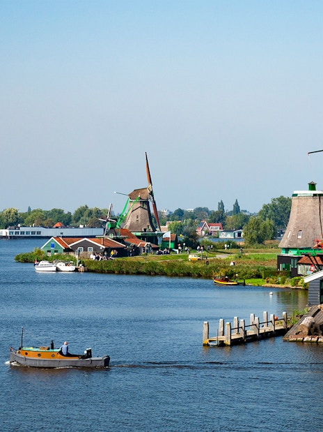Zaanse Schans windmills and boat on the river near Amsterdam.
