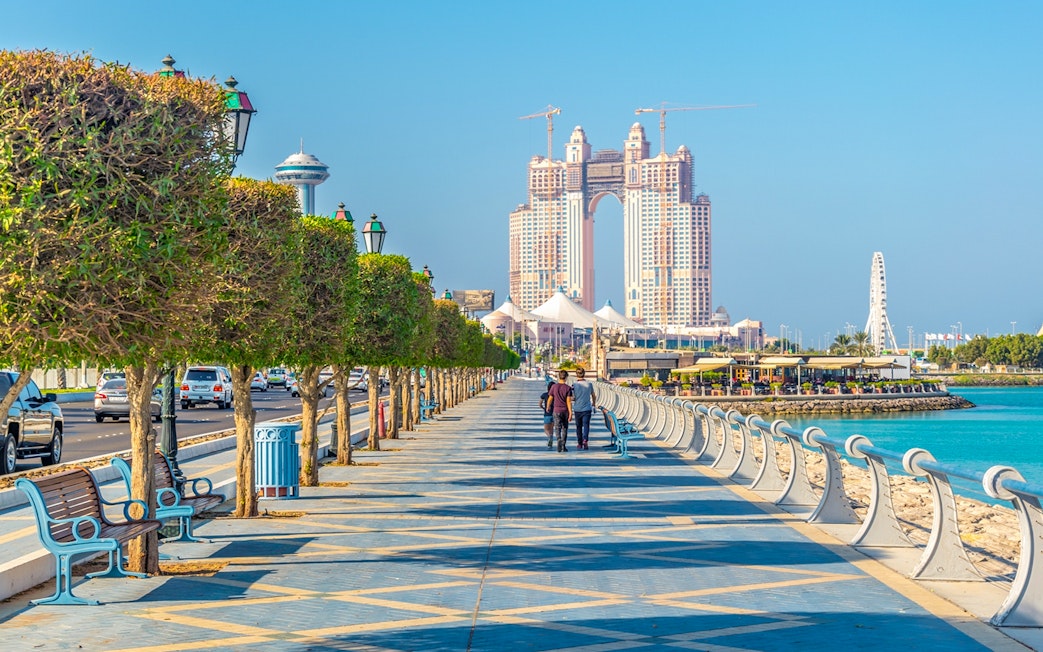 Abu Dhabi Corniche with skyscrapers and waterfront promenade, part of full-day sightseeing tour.