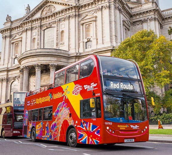Open-top double-decker bus in front of St. Paul's Cathedral, London.