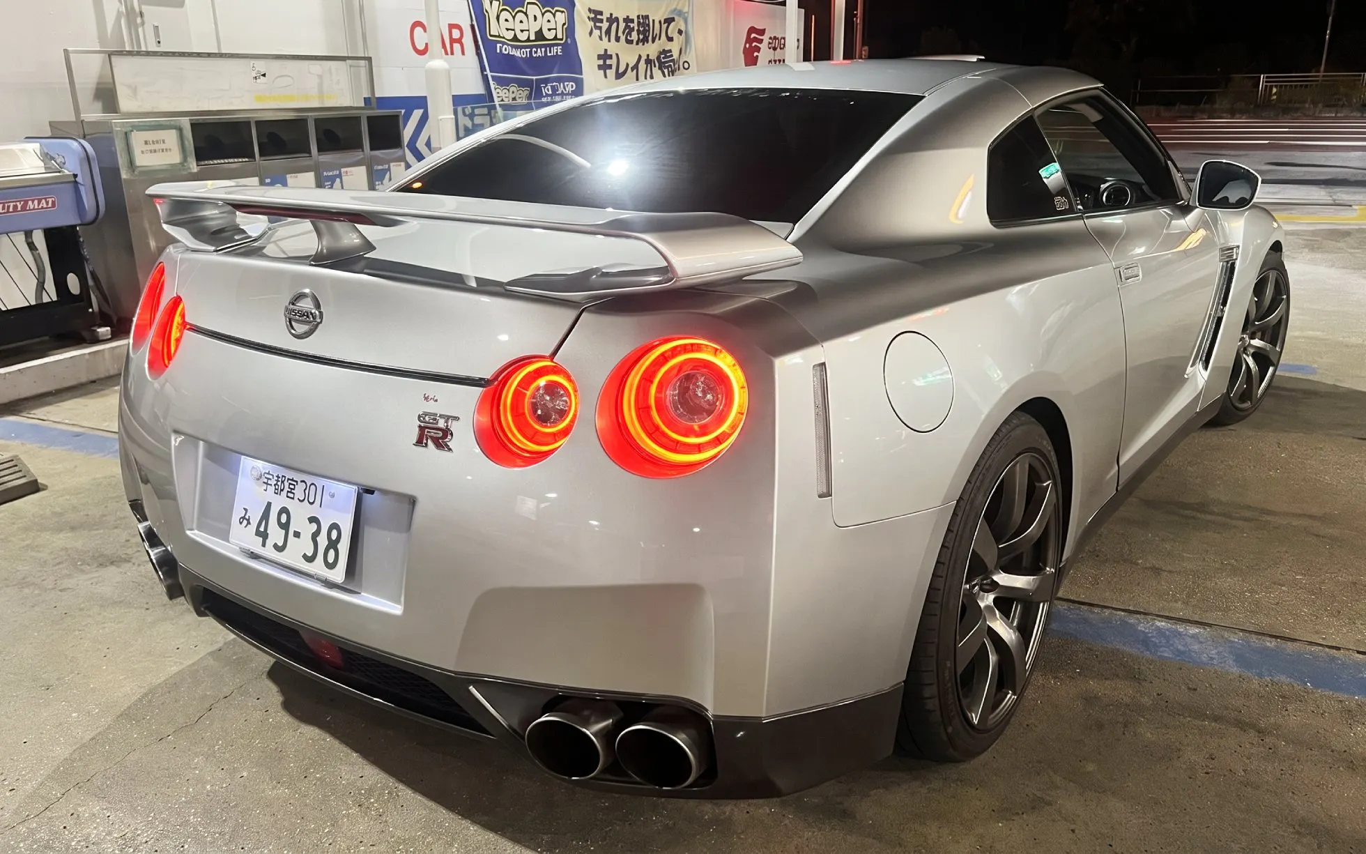 Silver Nissan GT-R at a Tokyo gas station for the Tokyo Drift 5.0 experience.