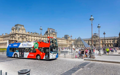 Tootbus double-decker bus in front of the Louvre Museum, Paris.