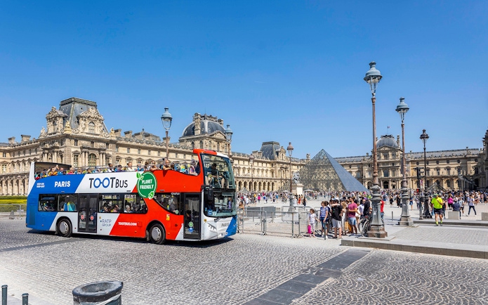 Tootbus double-decker bus in front of the Louvre Museum, Paris.
