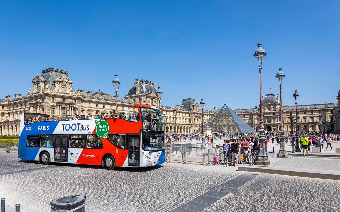 Tootbus double-decker bus in front of the Louvre Museum, Paris.