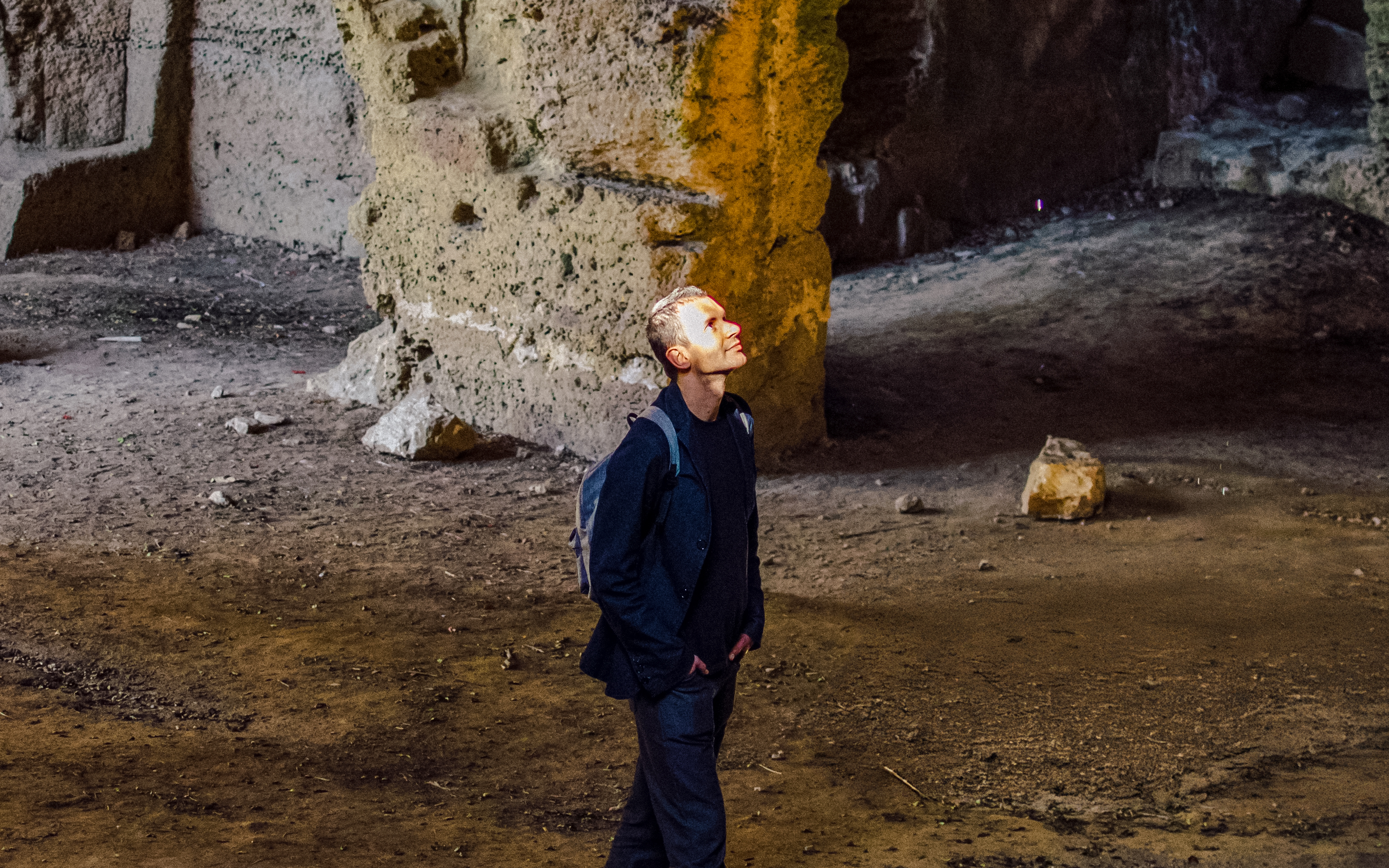 Tourist exploring ancient stone vault interior.