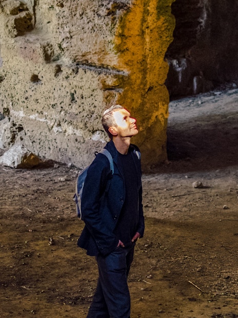 Tourist exploring ancient stone vault interior.