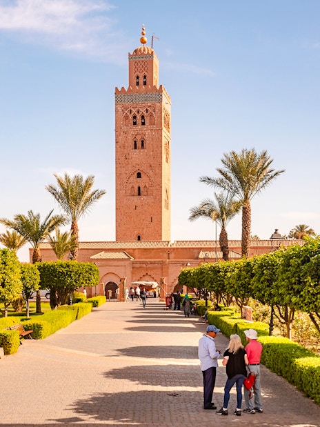Koutoubia Mosque with gardens and visitors in Marrakech, Morocco.