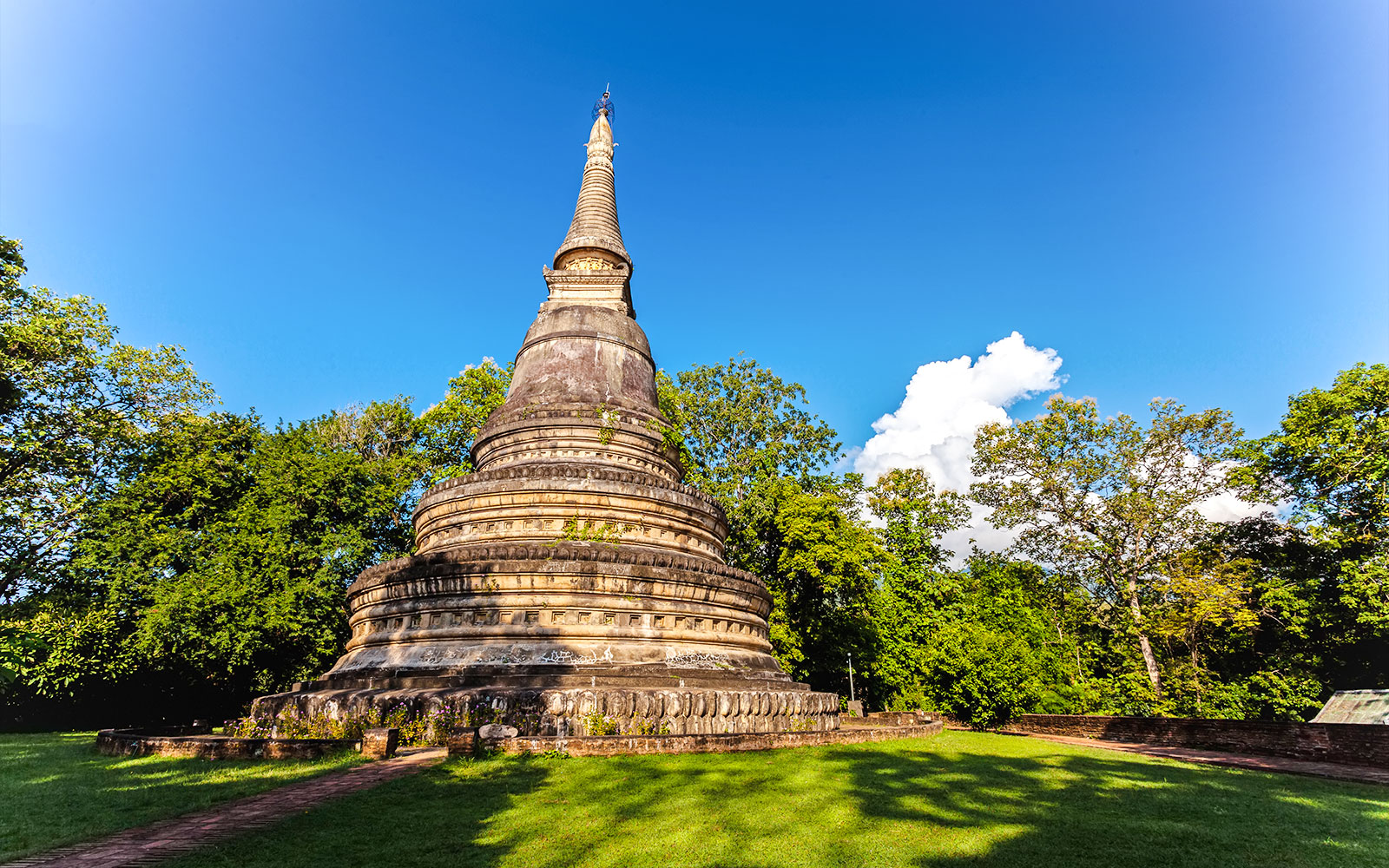 Ancient pagoda at Wat Umong surrounded by trees in Chiang Mai, Thailand.