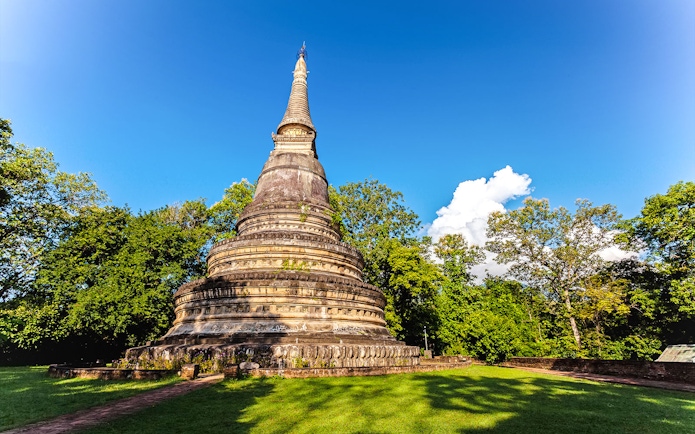 Ancient pagoda at Wat Umong surrounded by trees in Chiang Mai, Thailand.