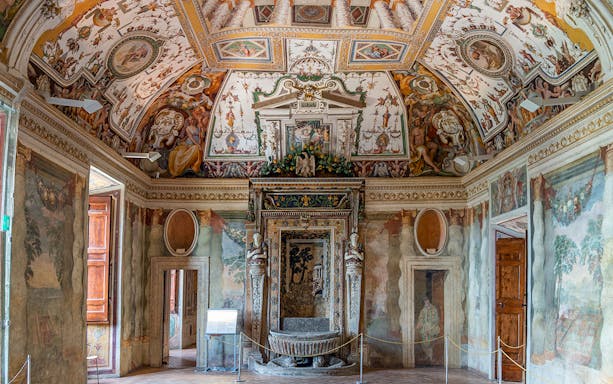 Hall of Hercules at Villa d'Este with ornate frescoes and detailed ceiling art.