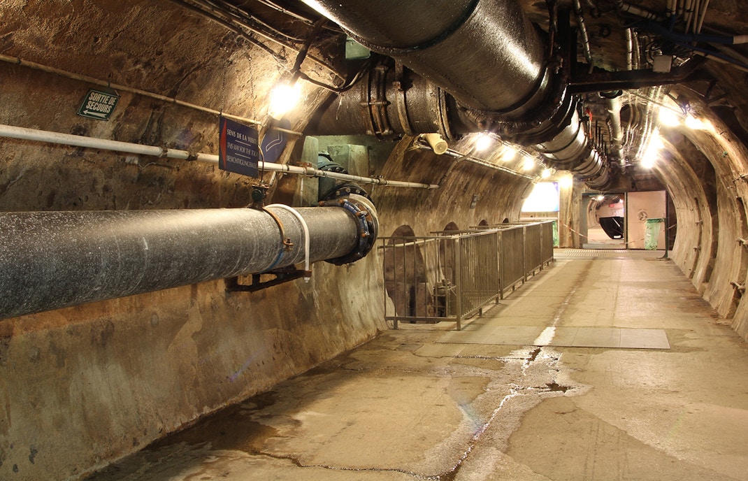 Underground passage with pipes at Paris Sewer Museum.