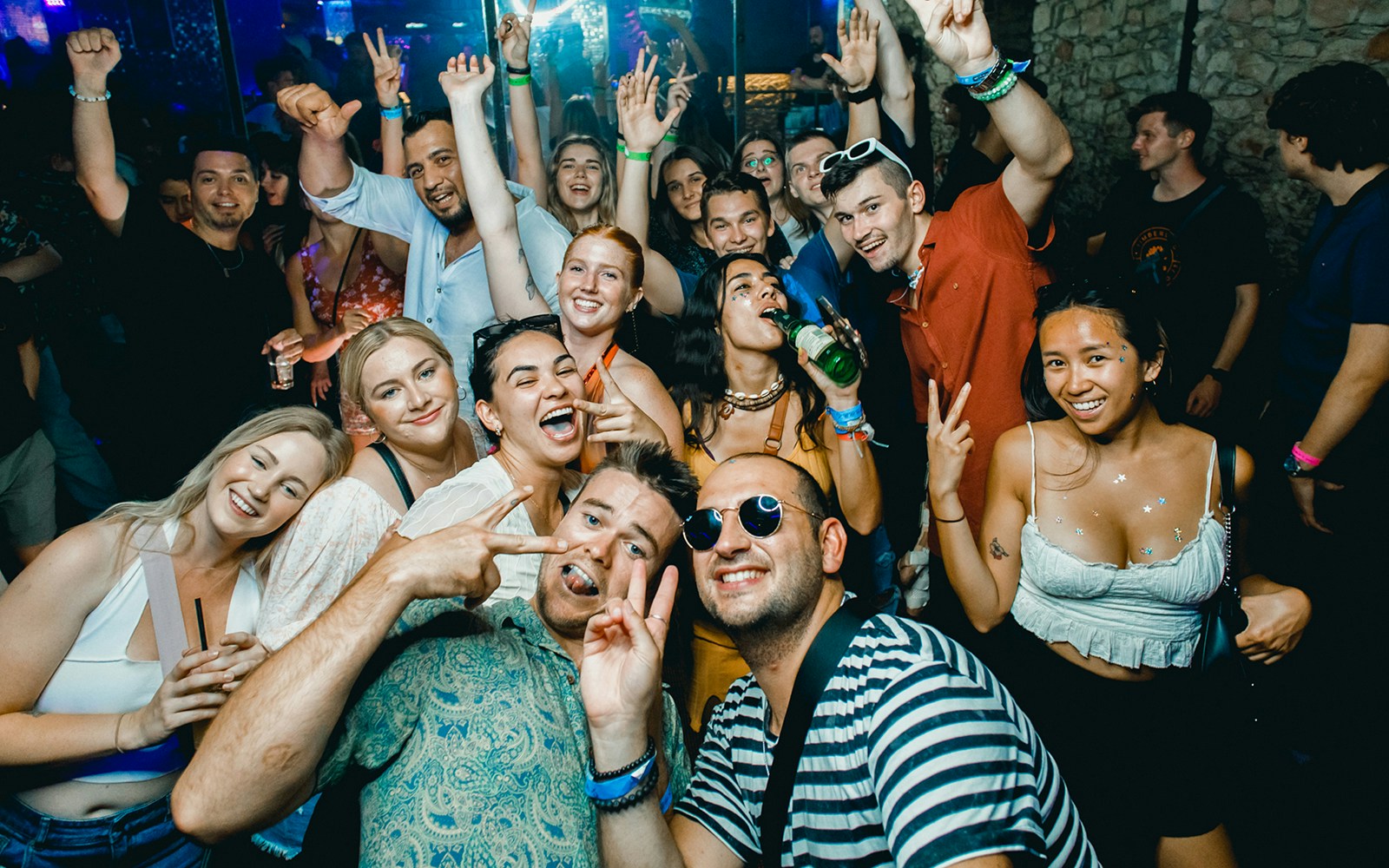 Group enjoying a lively boat party in Prague with drinks and dancing.