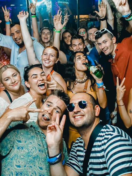 Group enjoying a lively boat party in Prague with drinks and dancing.