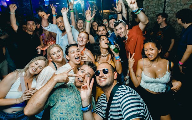 Group enjoying a lively boat party in Prague with drinks and dancing.