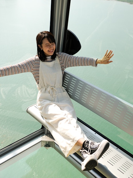 Person enjoying Ngong Ping Cable Car ride with scenic ocean view.
