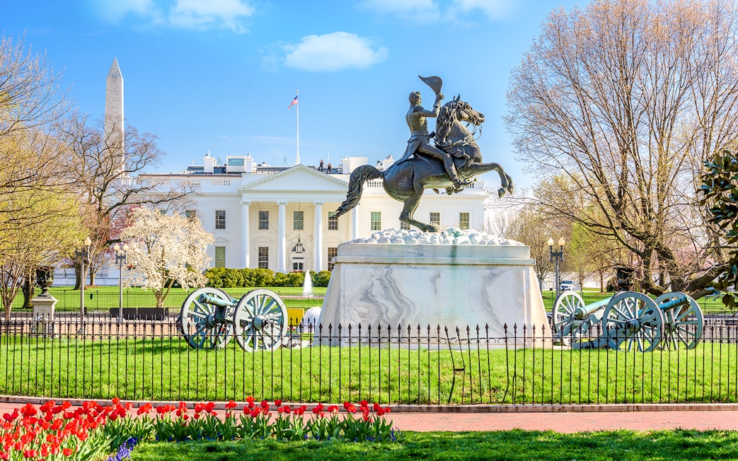 White House facade with equestrian statue and Washington Monument in Washington DC.