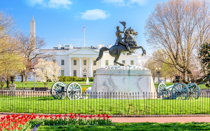 White House facade with equestrian statue and Washington Monument in Washington DC.