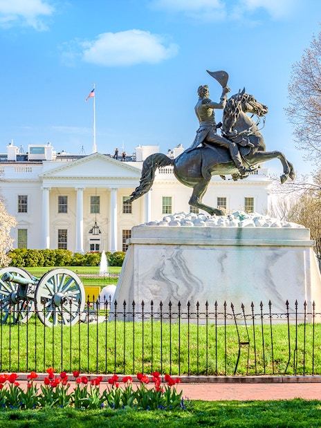 White House facade with equestrian statue and Washington Monument in Washington DC.