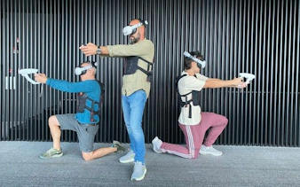 Three people wearing VR headsets and vests, engaging in a virtual reality experience at Lotte Hanoi Sky Chill 3, Dubai.