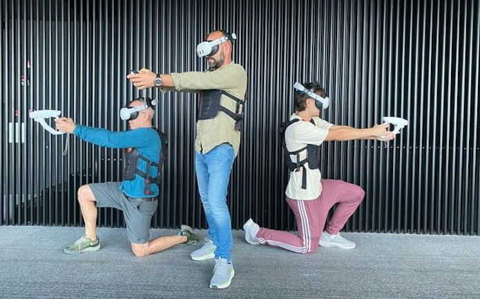 Three people wearing VR headsets and vests, engaging in a virtual reality experience at Lotte Hanoi Sky Chill 3, Dubai.