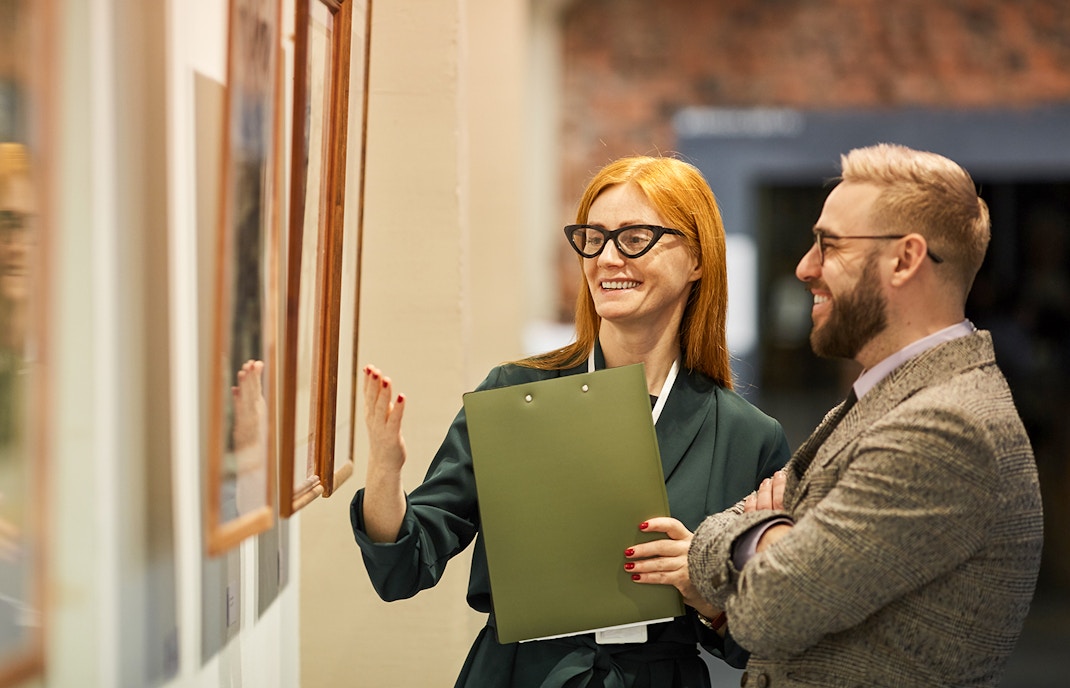Visitors admiring a gallery painting in a renowned art museum
