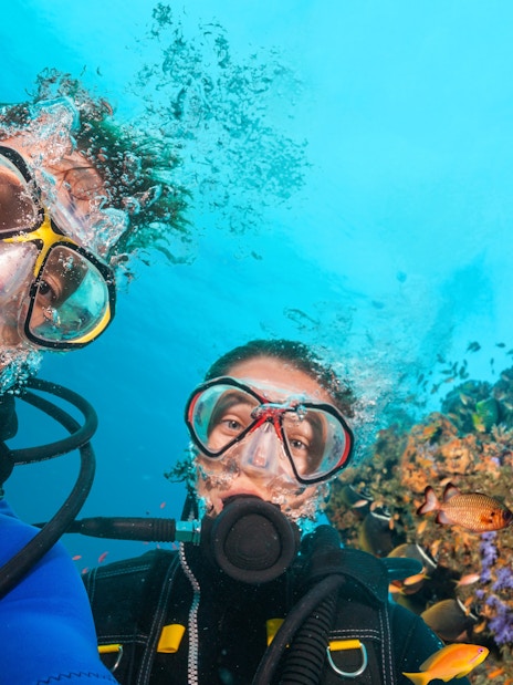 Scuba divers exploring vibrant coral reefs and colorful fish in the Red Sea, Hurghada.