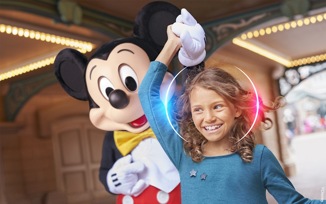 Child enjoying Disneyland Paris with a character.