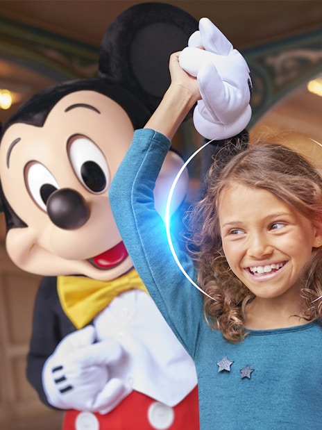 Child enjoying Disneyland Paris with a character.