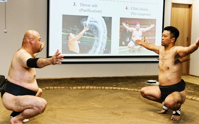 Sumo wrestlers demonstrating techniques during a live show in Osaka.