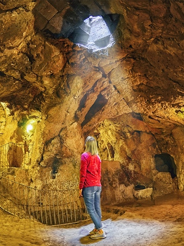 Person exploring Derinkuyu underground city in Cappadocia, Turkey.