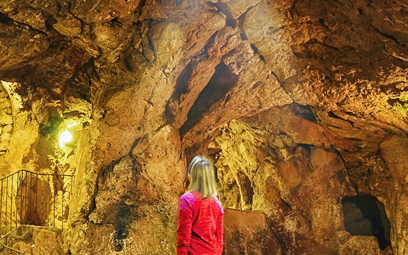 Person exploring Derinkuyu underground city in Cappadocia, Turkey.