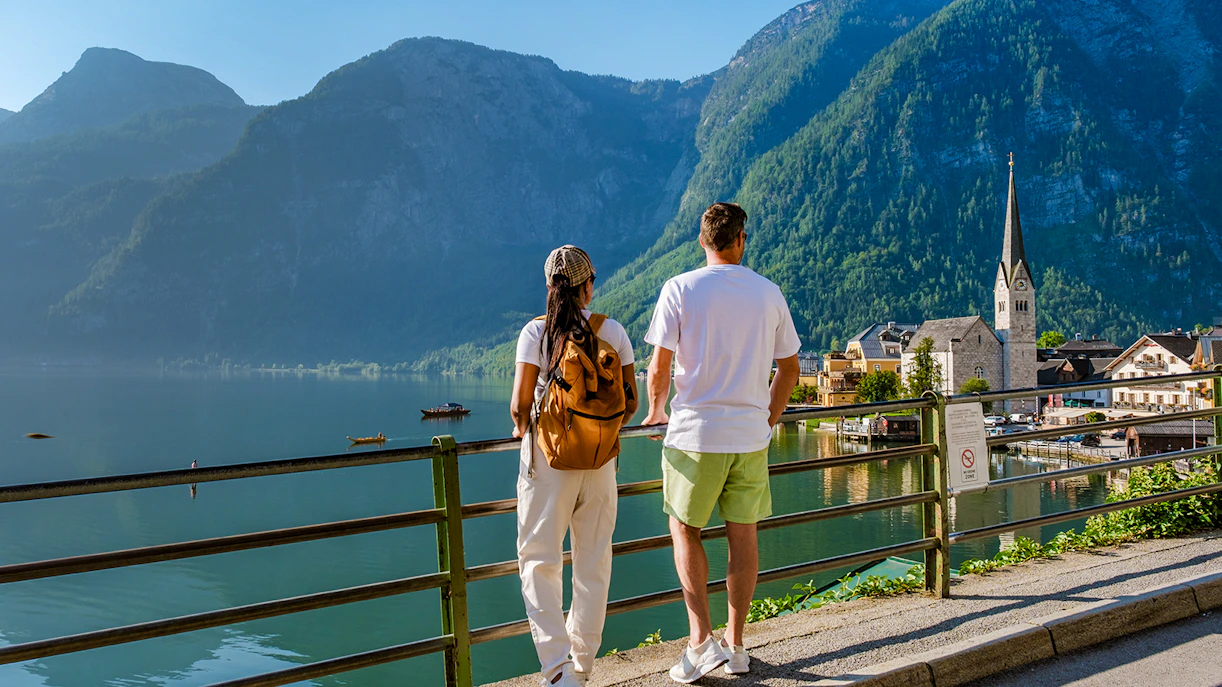 Couple overlooking Hallstatt village and lake with mountains in the background on a day trip from Vienna.