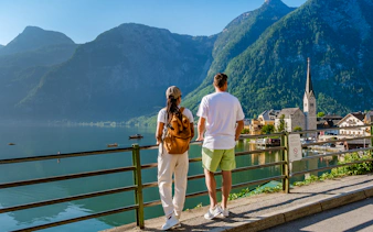 Couple overlooking Hallstatt village and lake with mountains in the background on a day trip from Vienna.