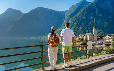 Couple overlooking Hallstatt village and lake with mountains in the background on a day trip from Vienna.