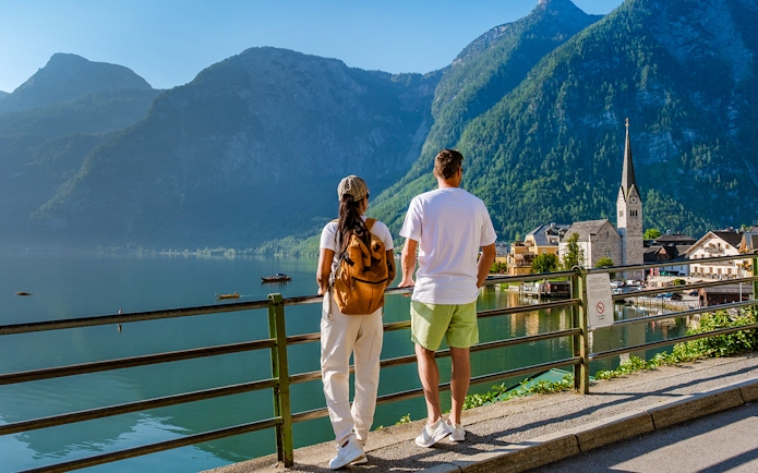 Couple overlooking Hallstatt village and lake with mountains in the background on a day trip from Vienna.