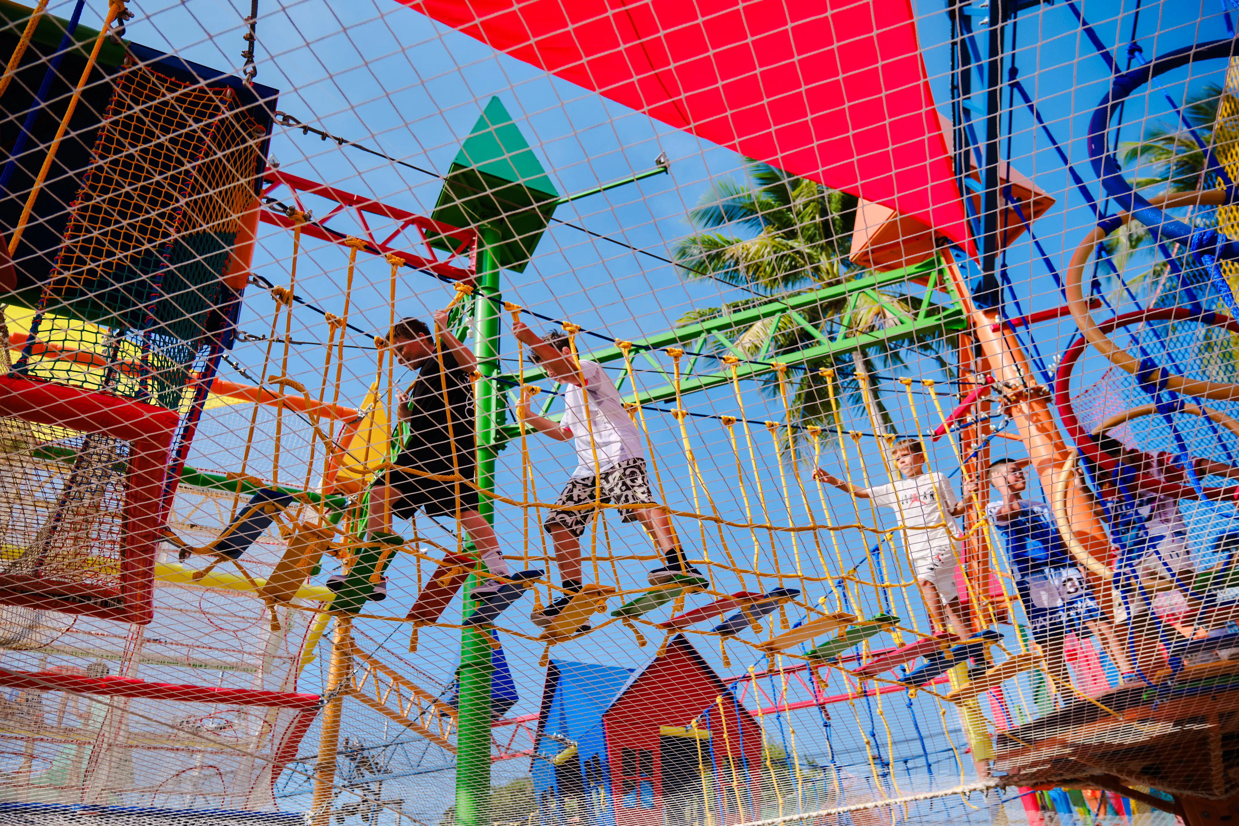 Children navigating a colorful rope course at a birthday party in Phuket.