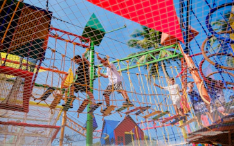 Children navigating a colorful rope course at a birthday party in Phuket.