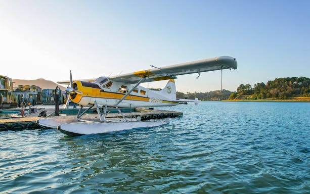 Seaplane docked on water with hills in the background, Golden Gate Seaplane Tour.