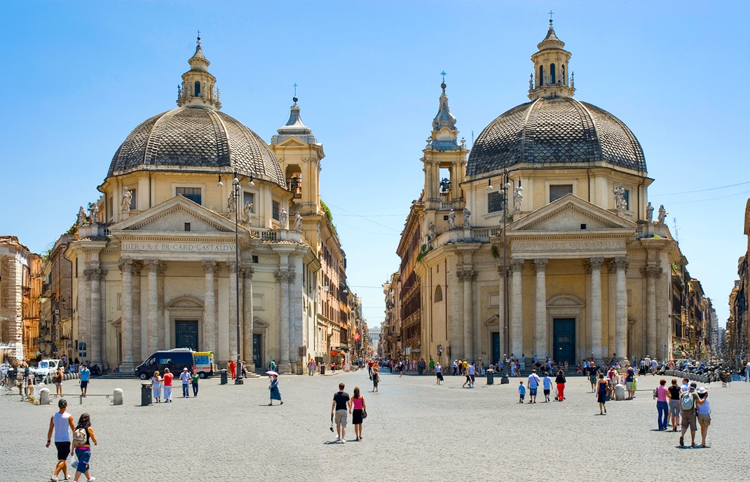Twin churches at Piazza del Popolo, Rome, with people walking in the square.