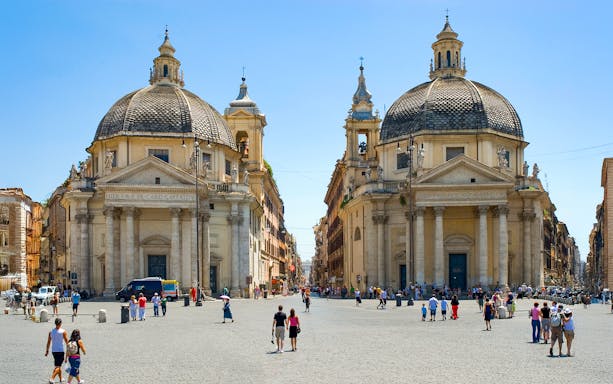 Twin churches at Piazza del Popolo, Rome, with people walking in the square.