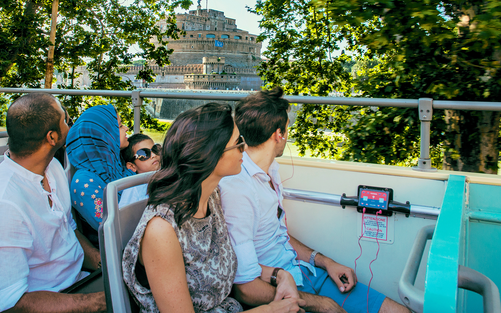 Travellers on a bus listening to an audio guide near Castel Sant'Angelo, Rome.